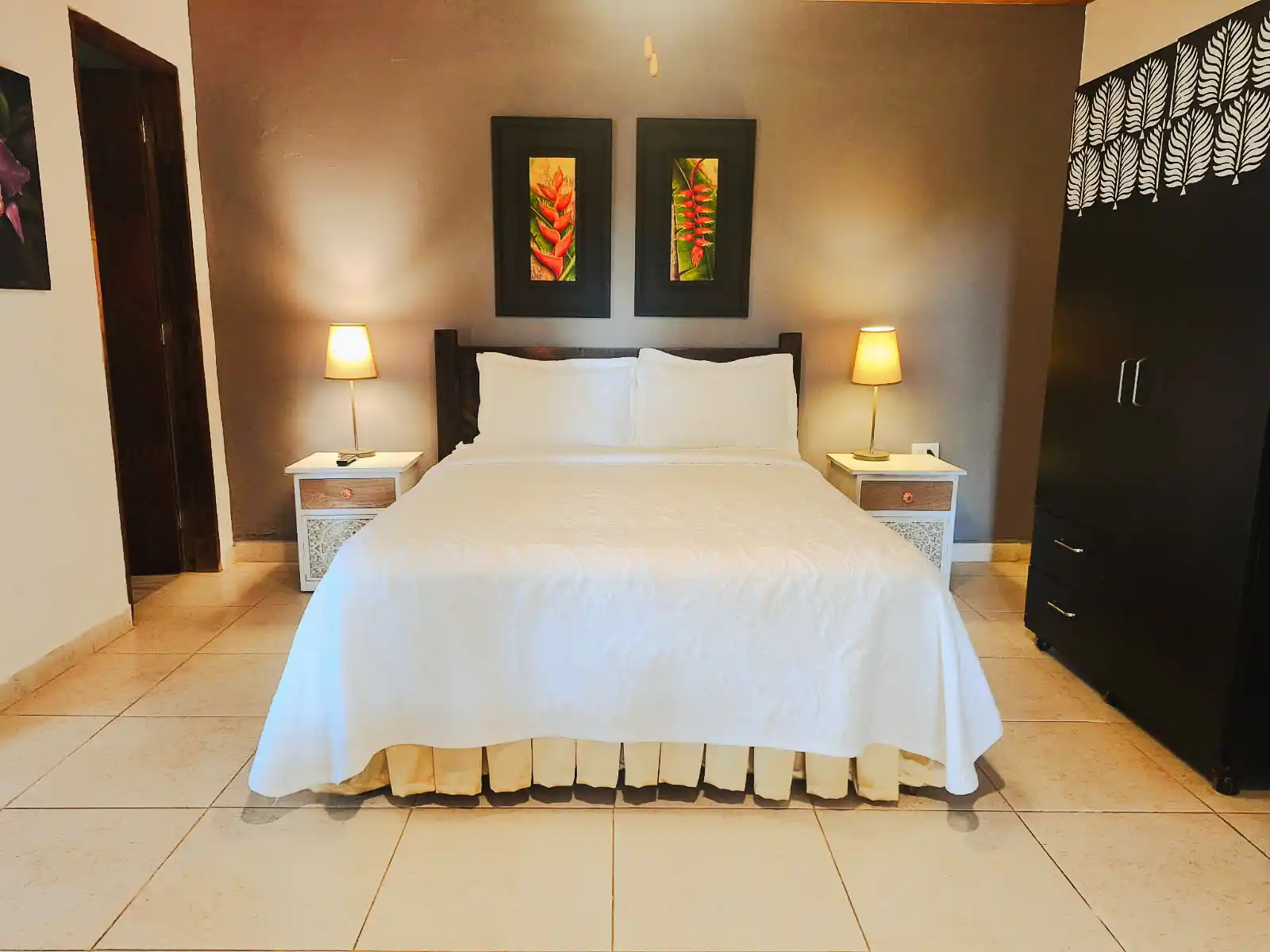 Habitación suite familiar con cama king, decoración tropical y mesitas de noche en hotel de Alcalá, Valle del Cauca.