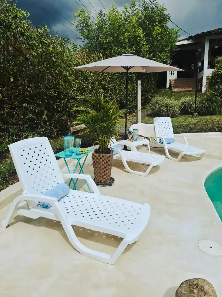Espacio de relax junto a piscina con sillas para sol en hotel o alojamiento en Alcala.