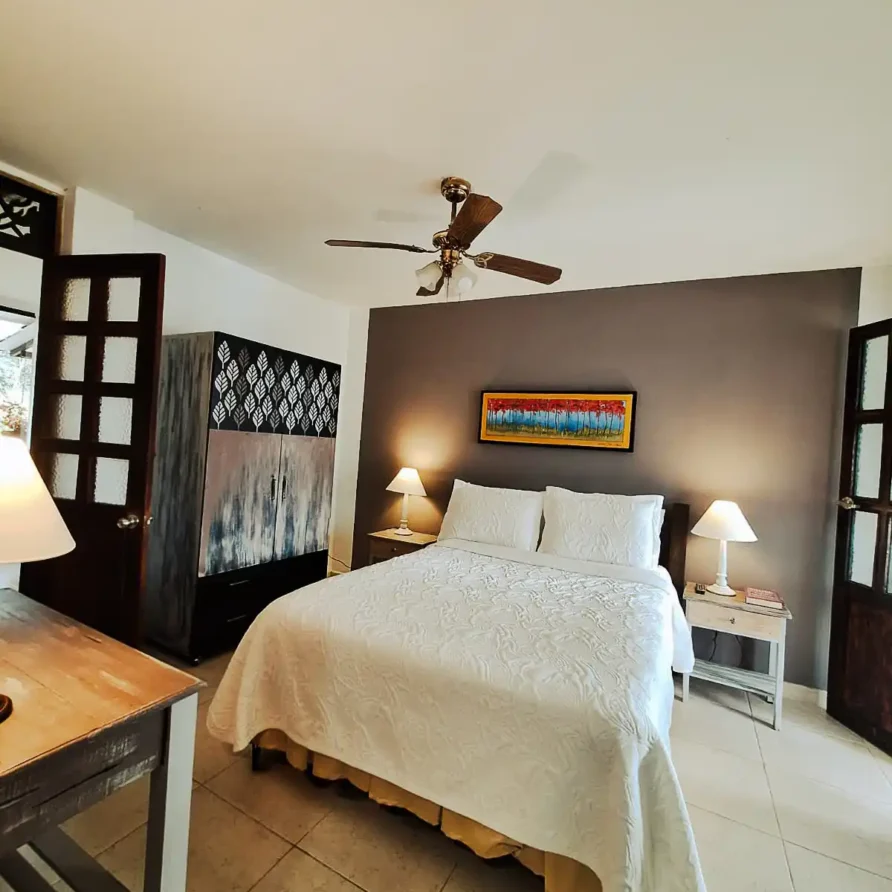 Amplia habitación de alquiler en casa finca hotel Alcalá, con cama doble, muebles de madera y ambiente cálido.