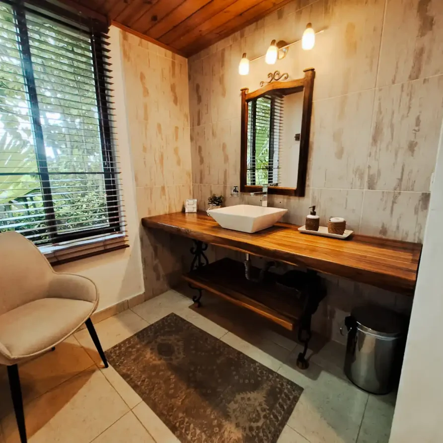 Cuarto de baño confortable en alojamiento en Alcalá Valle del Cauca, mueble de madera y diseño acogedor.