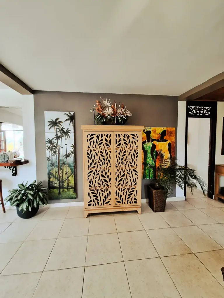 Mueble decorativo de madera y arte tropical en zona común de finca hotel en Alcalá, Valle del Cauca.
