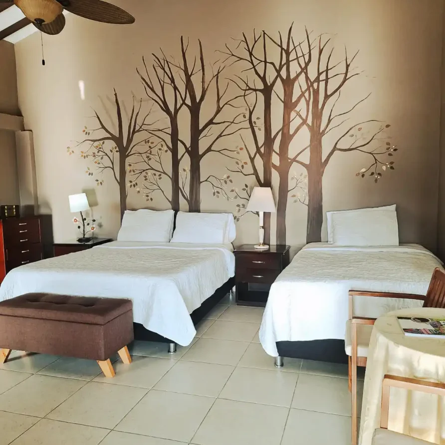 Alojamiento en Alcalá Valle del Cauca: suite confortable con dos camas, decoración natural y mesitas de noche.